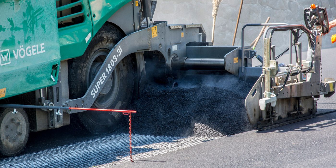 eine Straßenmaschine des Unternehmens Vendruscolo legt Asphalt aus