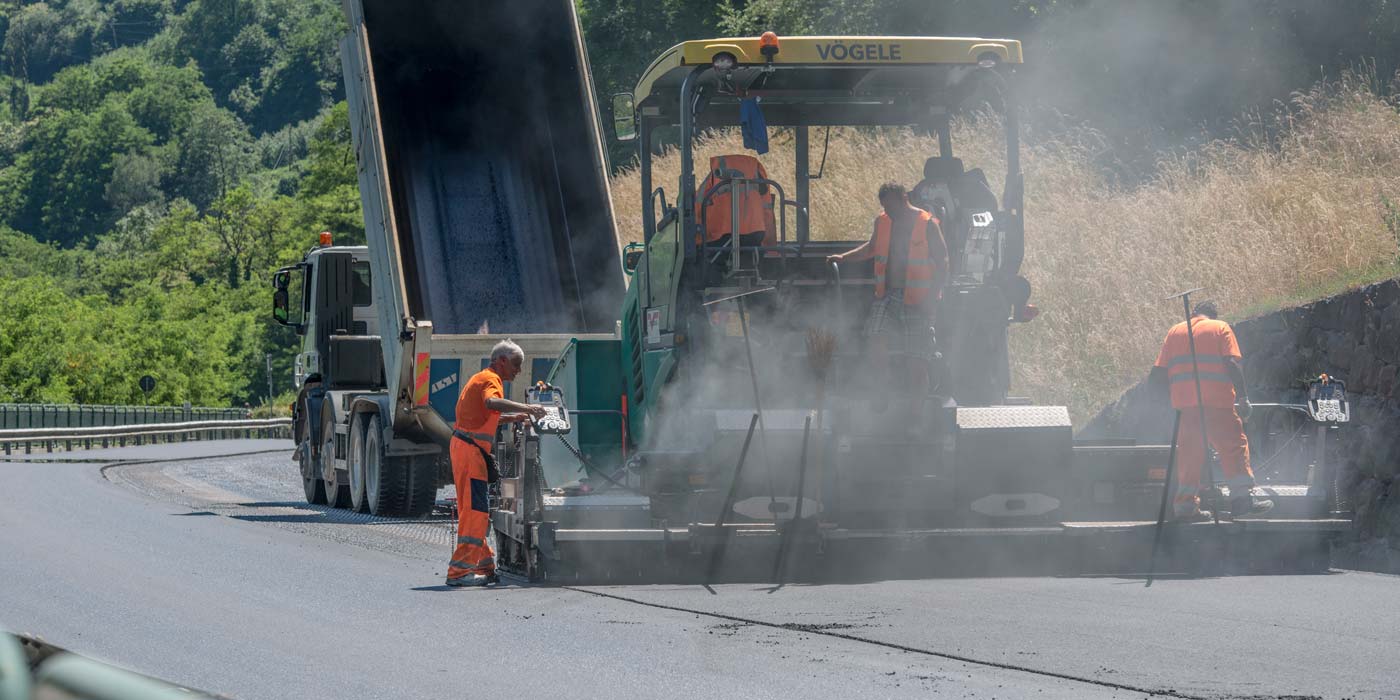 Degli operai dell'impresa Vendruscolo procedono con l'asfaltatura delle strade